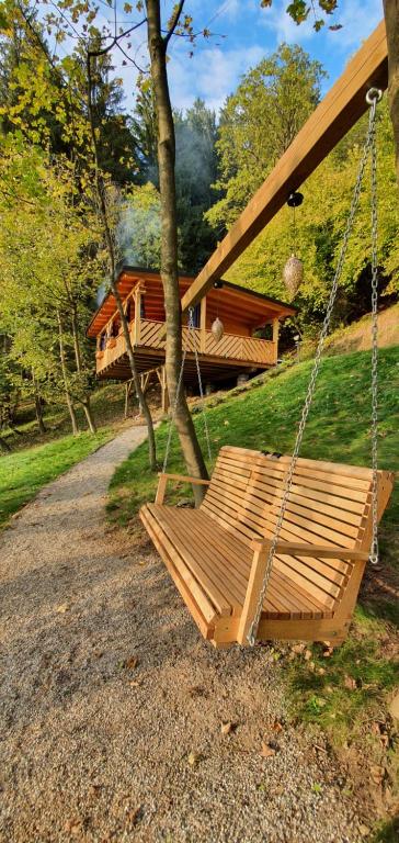 a swing in a yard with a house in the background at Hiska Na Samem v Slovenj Gradcu in Slovenj Gradec