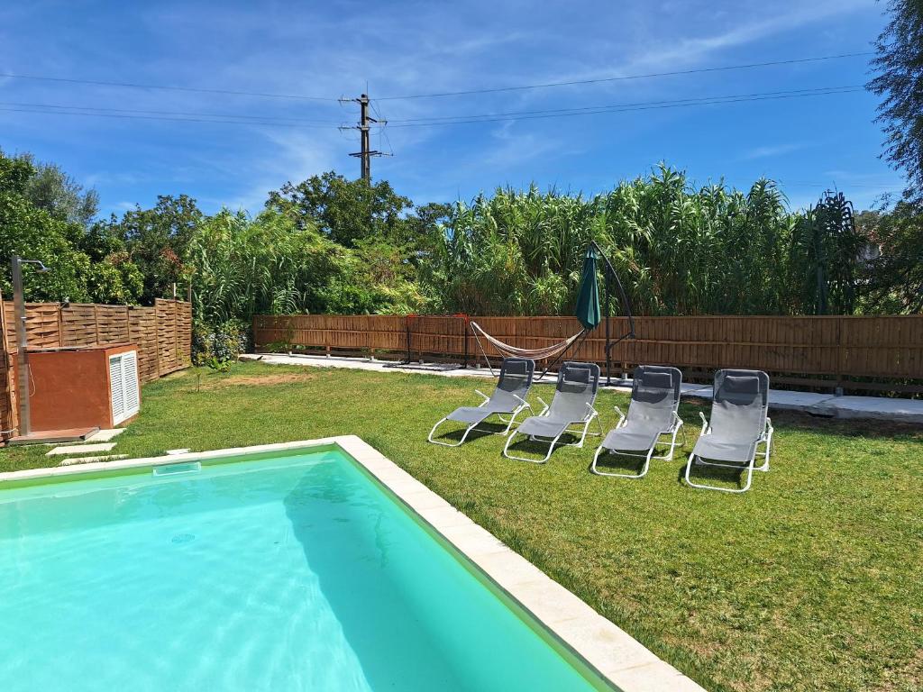 a yard with chairs and a swimming pool at Casa da Ribeira in Alcanede