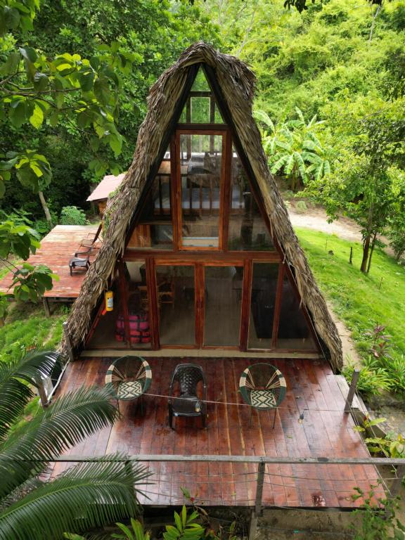 uma pequena casa com um telhado de palha num deque de madeira em Tiny Houses Unique Tayrona - Dentro del Parque Tayrona em El Zaino