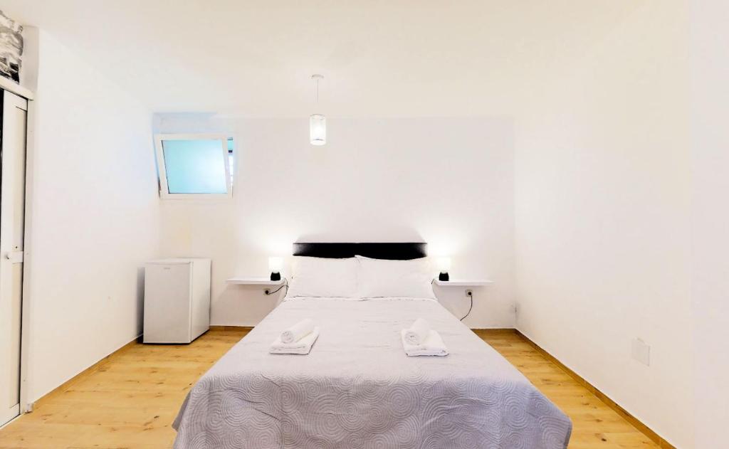 a white bedroom with a bed with two towels on it at sobe 1-2-3 in Split