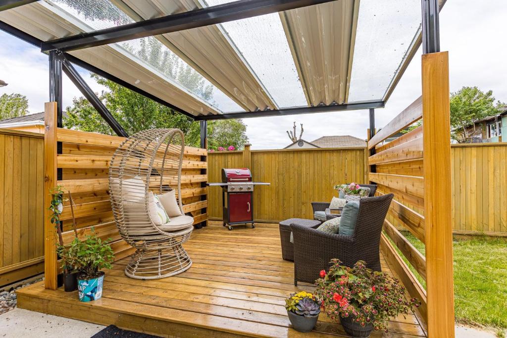 eine Holzterrasse mit einer Pergola und Stühlen darauf in der Unterkunft Home near Downtown Vancouver East@ Joyce Skytrain in Vancouver