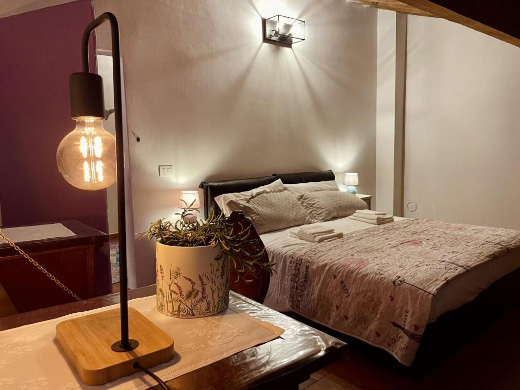 a bedroom with a bed and a table with a lamp at Modì Loft in Livorno