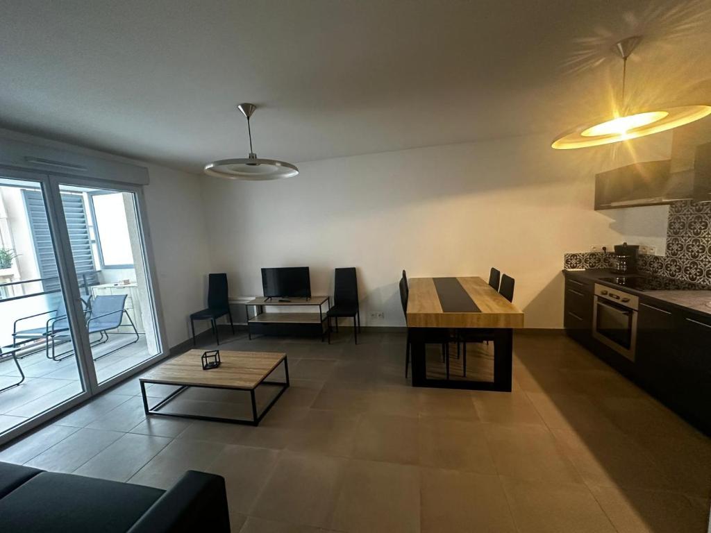 Il dispose d'une cuisine et d'un salon avec une table et une table. dans l'établissement Superbe Appartement terrasse 2P à 5 min à pied du vieux Nice, du port et du Tram, à Nice