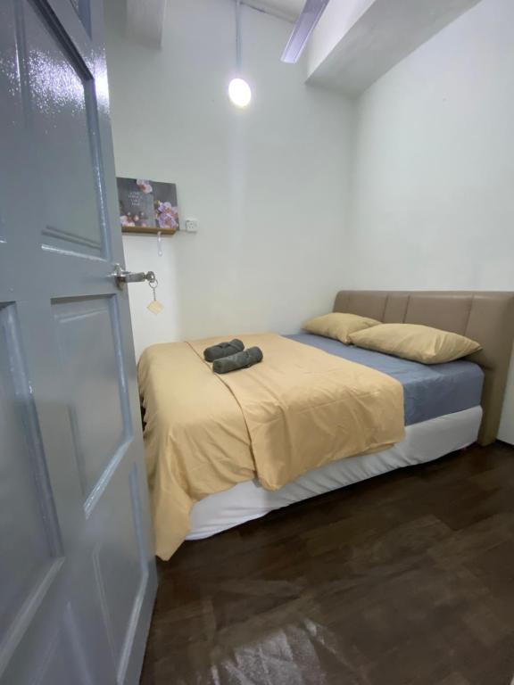 1 dormitorio con 1 cama y puerta a una habitación en RumahRehat, en Kampong Molek