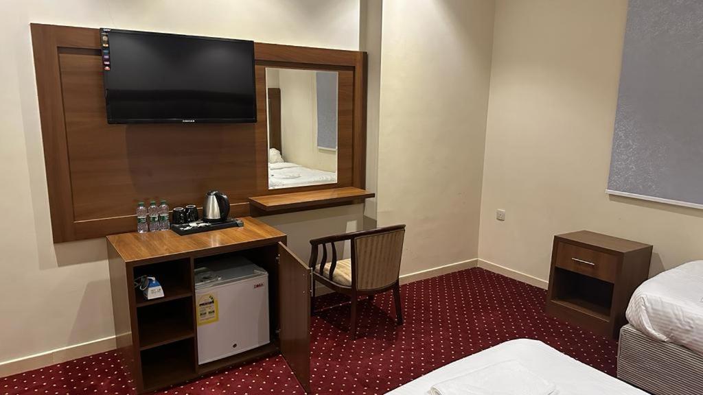 ARAEK AL KHLOOD HOTEL في مكة المكرمة: غرفة في الفندق مع تلفزيون ومرآة