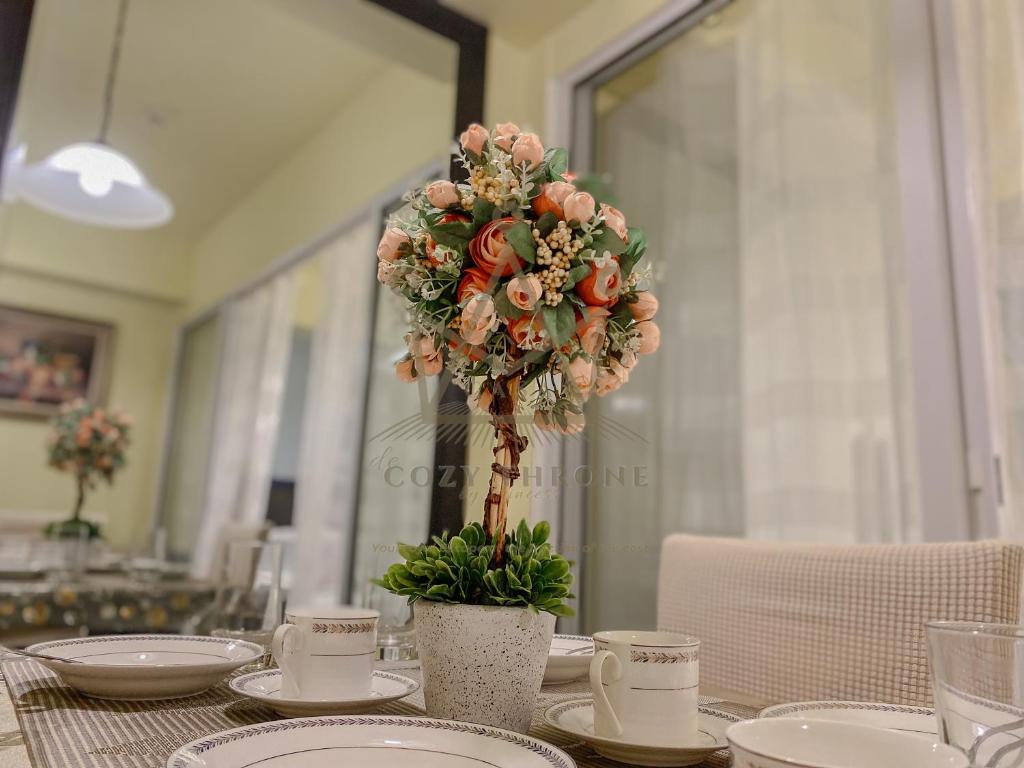 einen Tisch mit Blumenarrangements darüber in der Unterkunft Minimalist Luxury Condo Classic Aesthetic at Azure in Manila