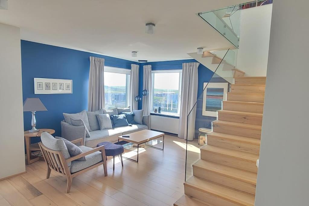 a living room with a couch and a stair case at Pent house dublex with amazing city and Ocean views for 4 rooms 6 people in Reykjavík