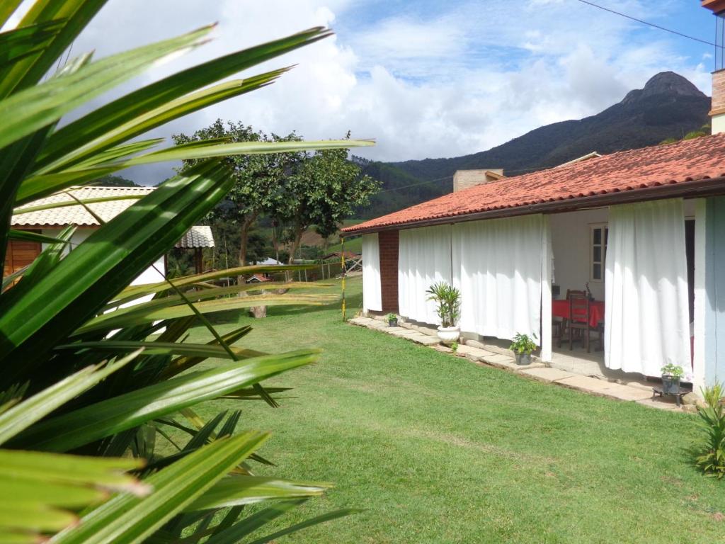 uma vista para uma casa com montanhas ao fundo em Passarinhada Hospedagem em Domingos Martins