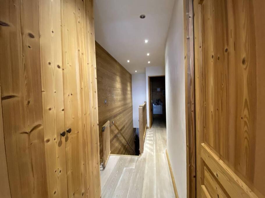 a hallway with wooden walls and a wooden door at Alpe d&#39;Huez Houses - Chalet des Roches - Duplex, SUR les pistes de 3 chambres ! in LʼHuez