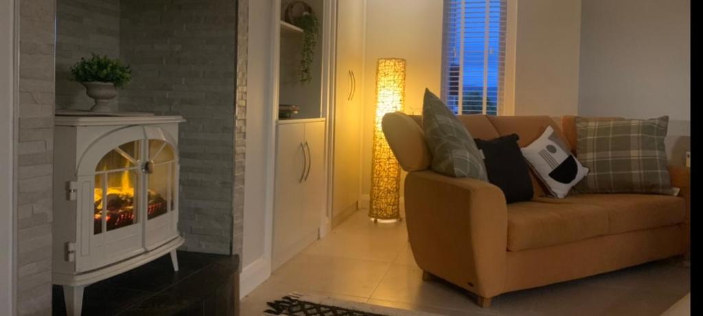 a living room with a couch and a fireplace at Ivy Lane in Loughanure