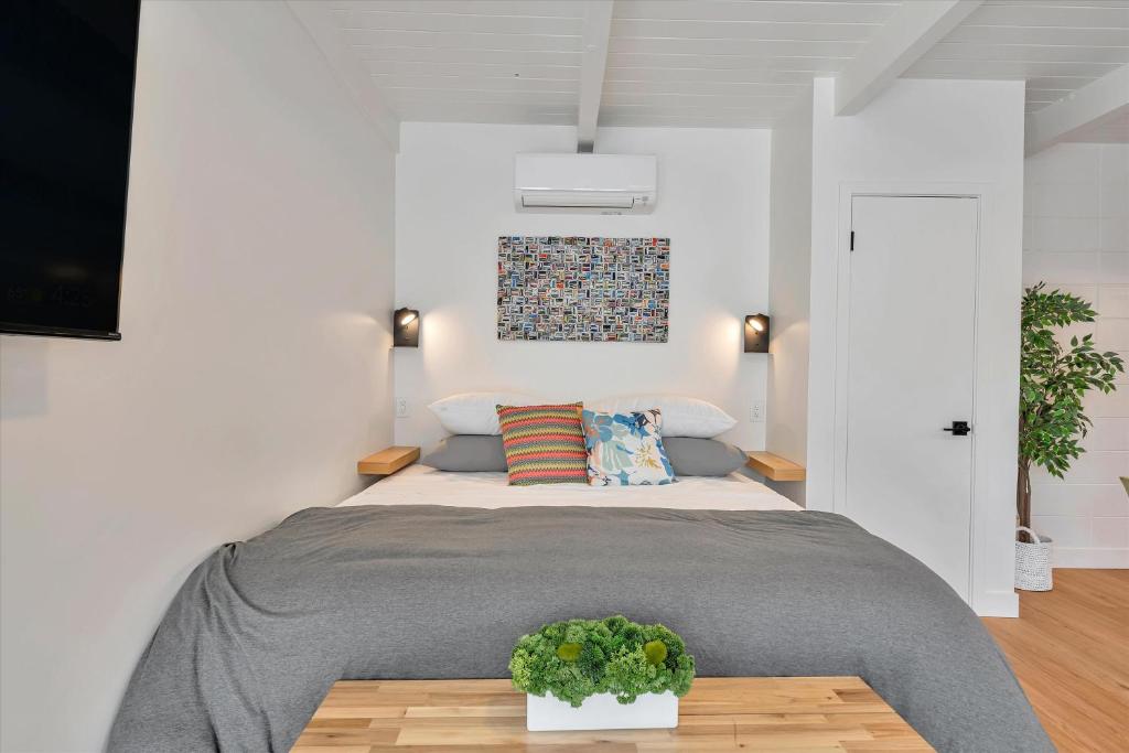 a bedroom with a bed and a table with a plant at Silicon Valley Stay Apartments in San Carlos