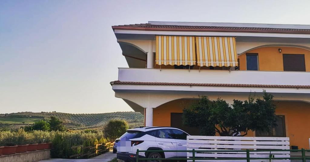 un coche blanco estacionado frente a un edificio en Villa Rosa B&B, en Sellia Marina