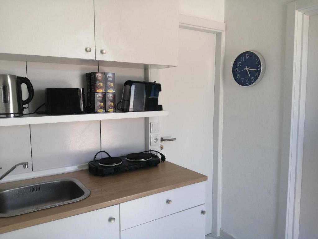 una cocina con fregadero y un reloj en la pared en Retiro dos sonhos en Porches