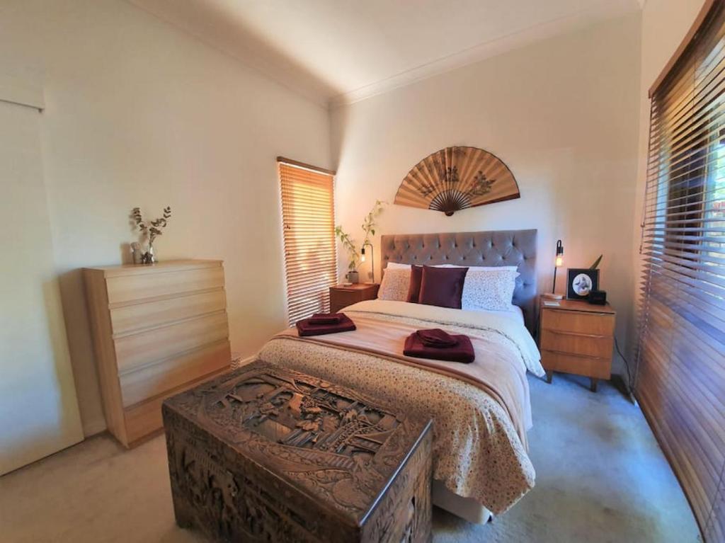 a bedroom with a large bed with a wooden headboard at Eden on Young Street in Wayville