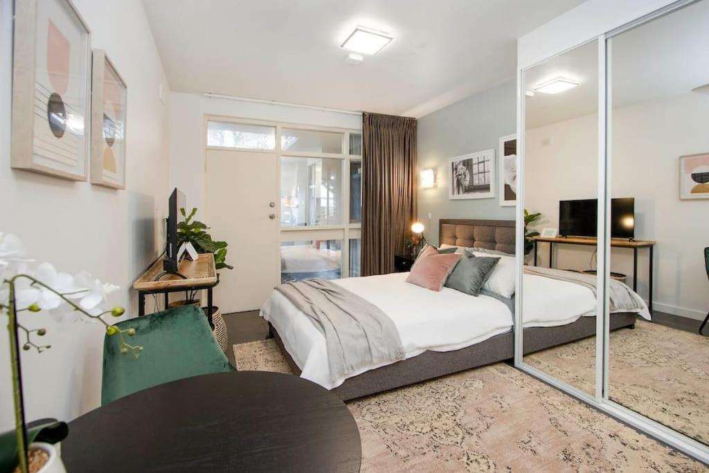 um quarto com uma cama e uma parede de vidro em Boho on Sussex North Adelaide em Adelaide