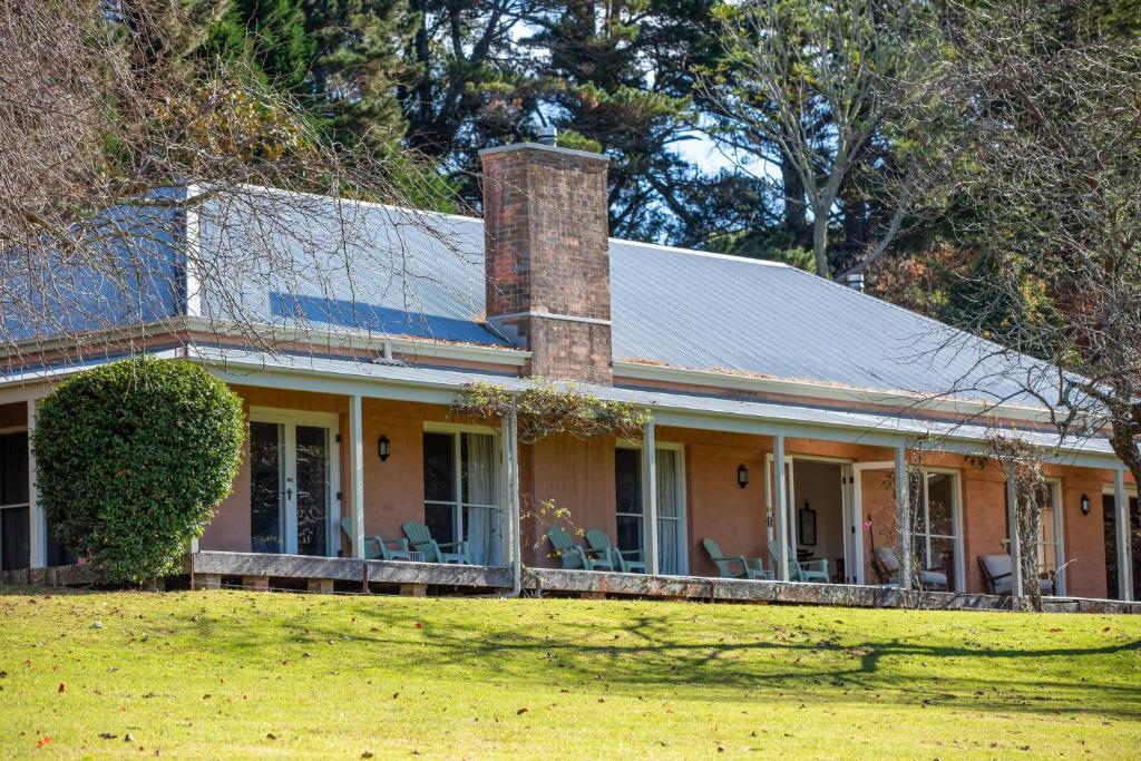 a house with a brick chimney on top of a yard at Good Dog Hill Homestead in Bellawongarah