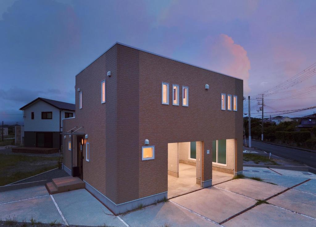 a large brick building with windows on a street at Crystal Besso Uminomachi in Shirahama