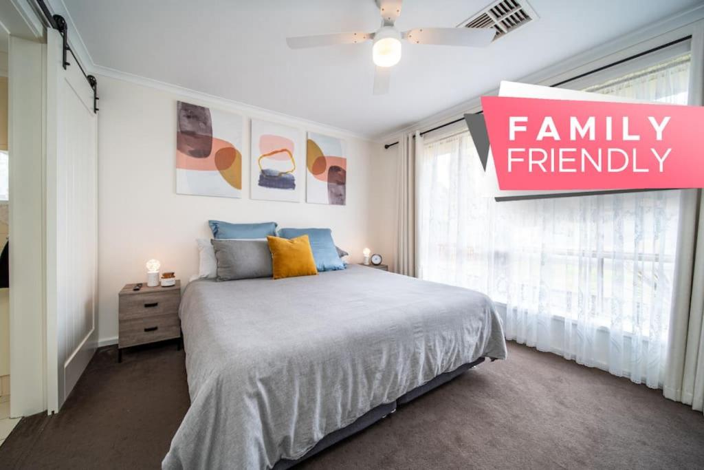 um quarto com uma cama grande e uma placa familiar em Escape to Adelaide Hills 