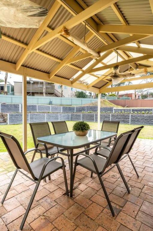 a patio with a table and chairs under a roof at Escape to Adelaide Hills - Spacious Country Stay in Nairne