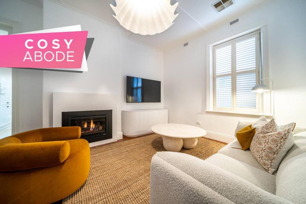 a living room with a couch and a fireplace at Netley Cottage Eastwood in Rose Park