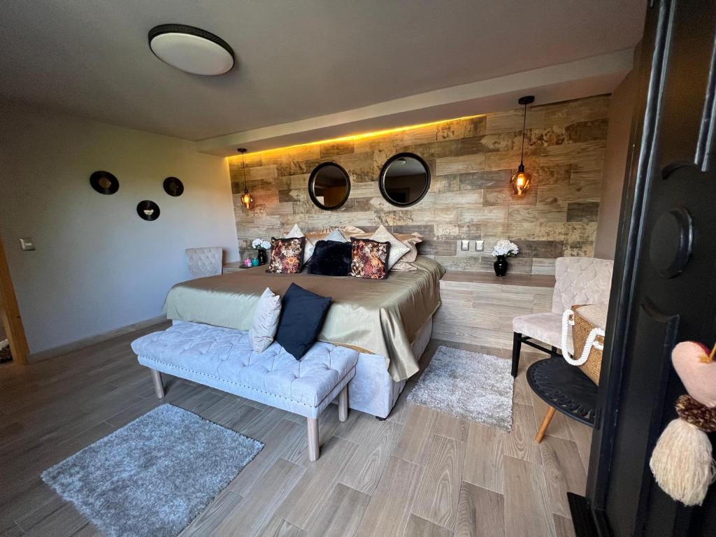 ein Schlafzimmer mit einem Bett, einer Couch und Spiegeln in der Unterkunft DEPARTAMENTO VILLA NEEK in San Cristóbal de las Casas