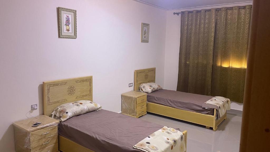 Cette chambre comprend 2 lits et une fenêtre. dans l'établissement Saidia caracas M, à Saïdia
