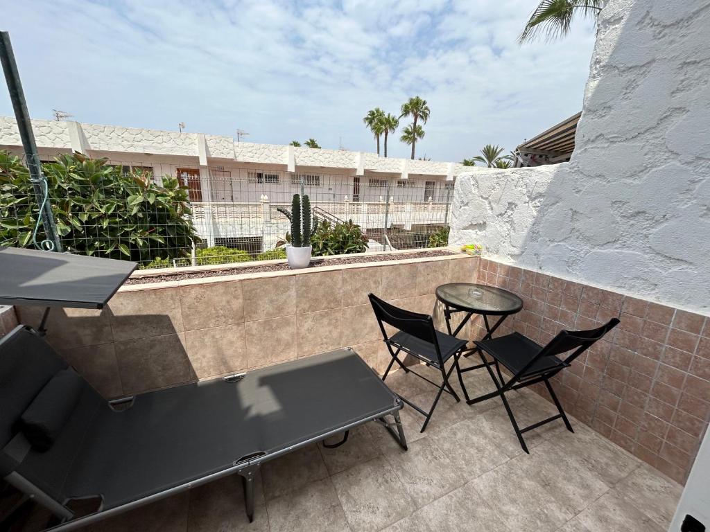 a patio with two chairs and a table on a wall at Practical and cozy apartment in southern Arona in Arona