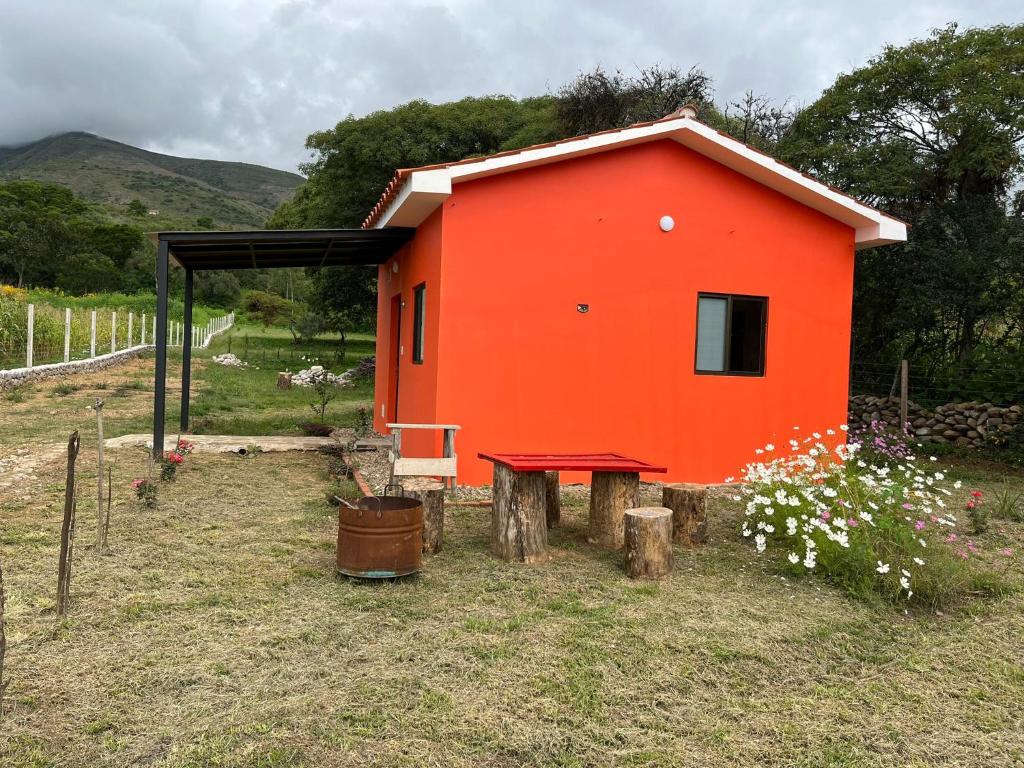an orange house with a picnic table in front of it at Armonia - La Victoria - Tarija in Tarija