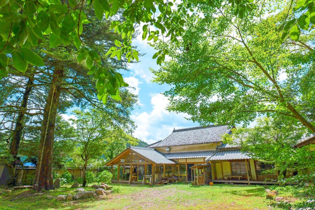 una casa en el bosque con árboles en 古民家オーベルジュmocca, en Kokuryō