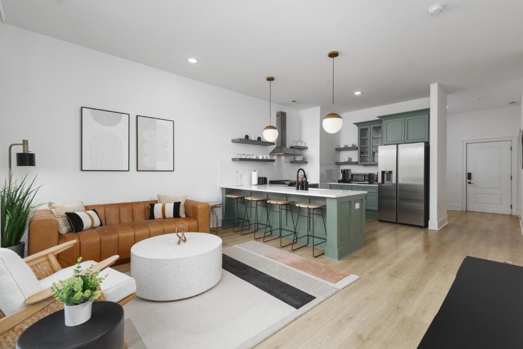 ein Wohnzimmer und eine Küche mit einer Couch und einem Tisch in der Unterkunft Trendy Spacious Condo, Walk to Coffee and Restaurants in Nashville