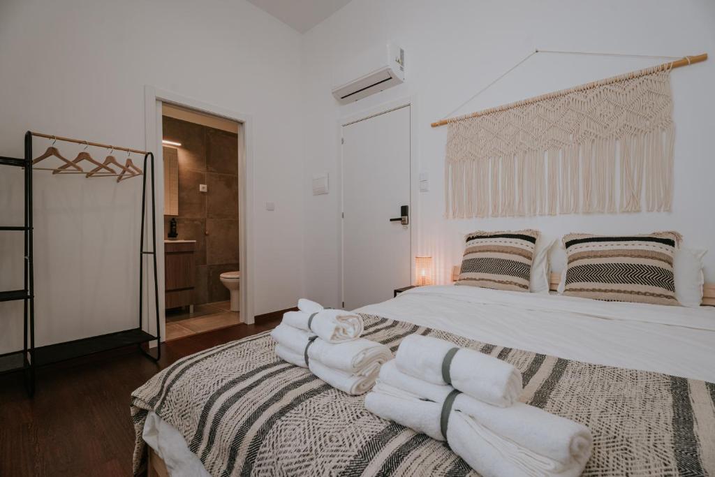 um quarto com uma cama grande e toalhas brancas em Porto Hostel Cúpula em Porto