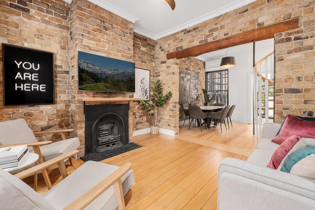 a living room with a brick wall and a fireplace at Ultimo l Renovated 2 Bedroom House With Rooftop Balcony in Sydney