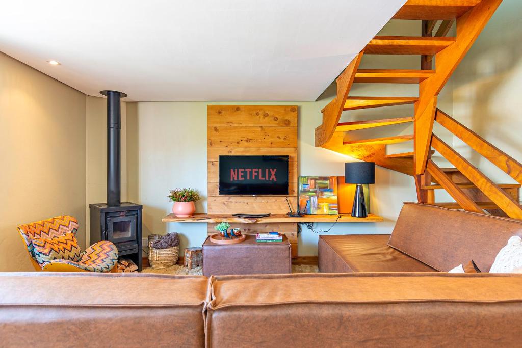 ein Wohnzimmer mit einem Sofa und einem Holzofen in der Unterkunft Sua Casa em Canela in Canela