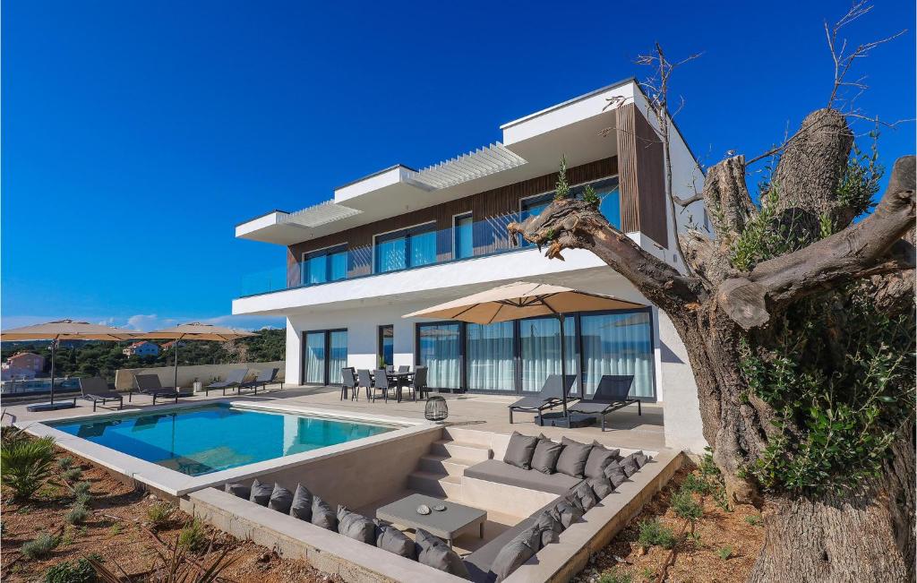 a house with a swimming pool in front of it at Vila Del Sol in Lun