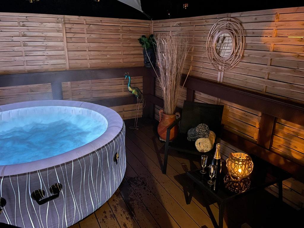 a jacuzzi tub in a room with wooden walls at La Résidence lac et montagnes privée jacuzzi 5 min du lac du Bourget 10 min d Aix les bains et Chambery in Voglans