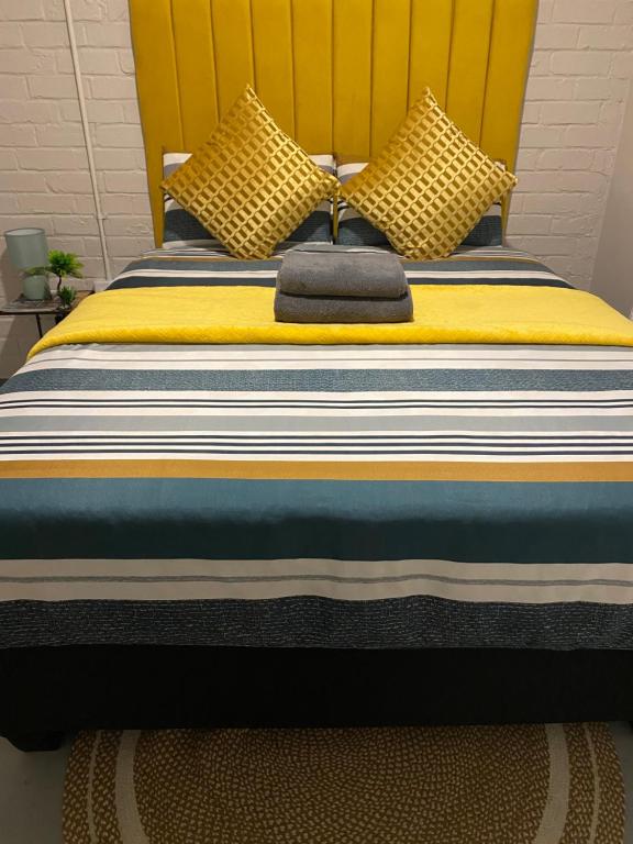 - un lit avec une tête de lit jaune et des oreillers dans l'établissement Apartment in Vibrant Maboneng, à Johannesbourg