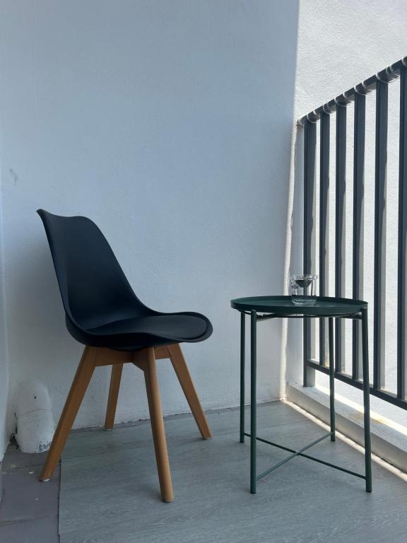 una silla negra y una mesa junto a un balcón en Imperio Armanistay Alor Star en Alor Setar