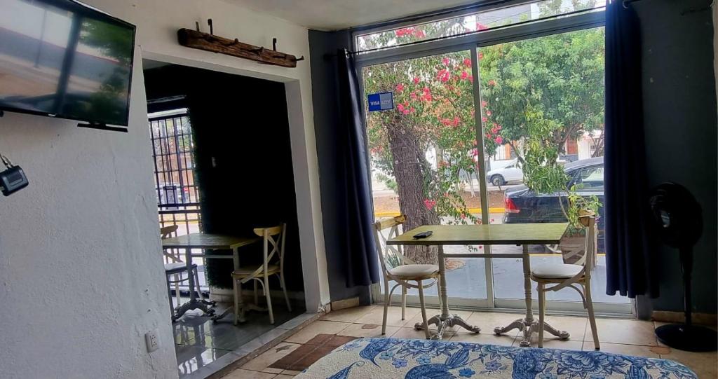 um quarto com uma mesa e cadeiras e uma janela em MINI HOTEL San Luis Potosí em San Luis Potosí