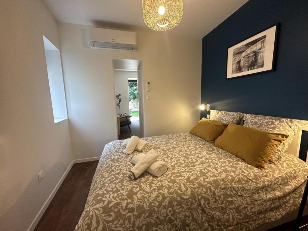 une chambre avec un lit avec deux oreillers dessus dans l'établissement Gîte calme en plein centre de Moulins avec terrasse privative et tout confort inclus - FR-1-489-475, à Moulins