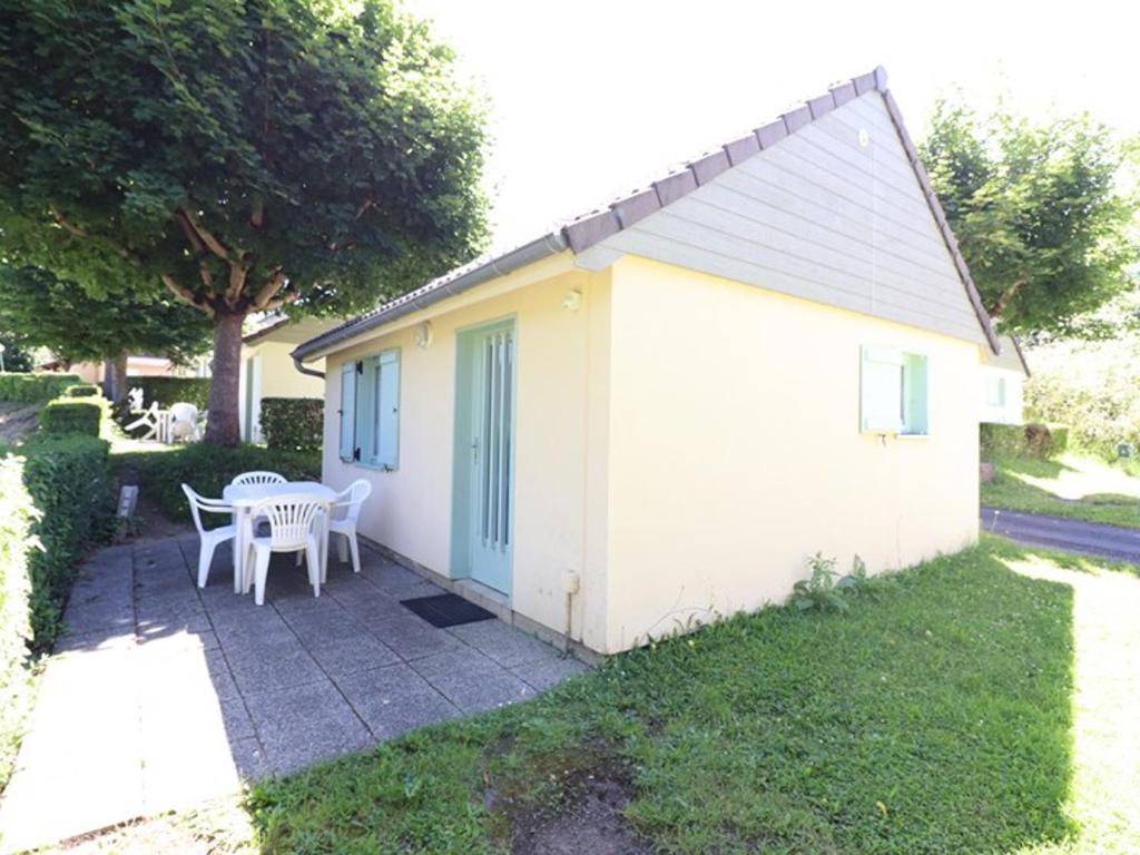 a small white building with a table and chairs at Gîte Arnac, 2 pièces, 4 personnes - FR-1-742-298 