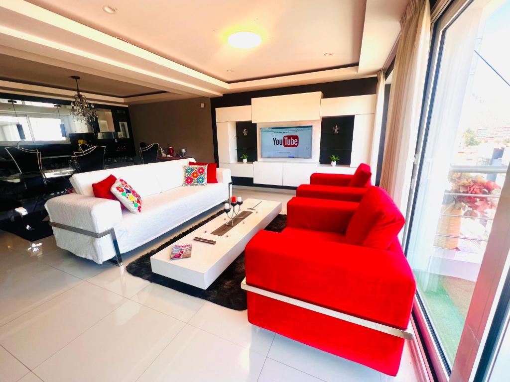 a living room with red and white furniture at Departamento La Terraza in Cusco