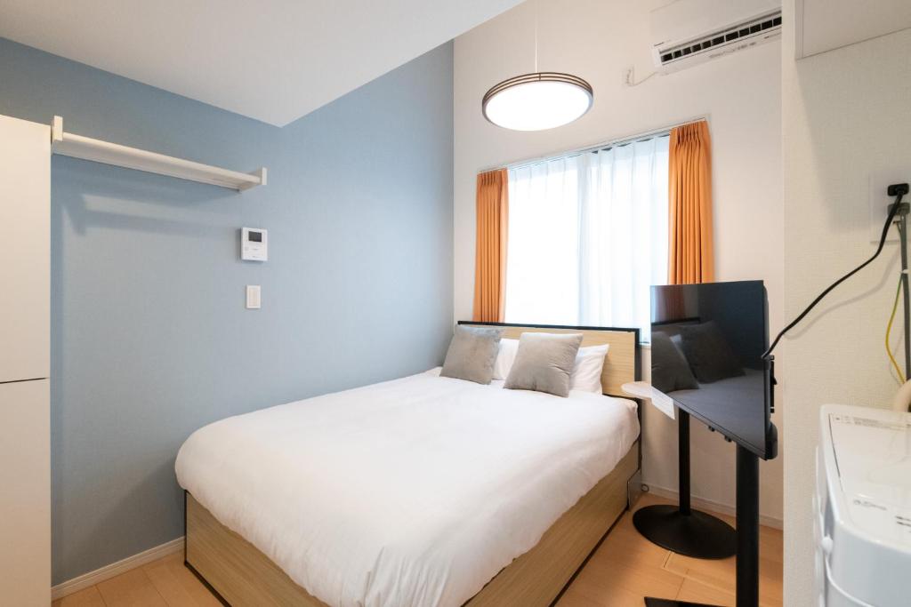 una piccola camera con letto e finestra di AZEST-RENT Haneda 11 a Tokyo