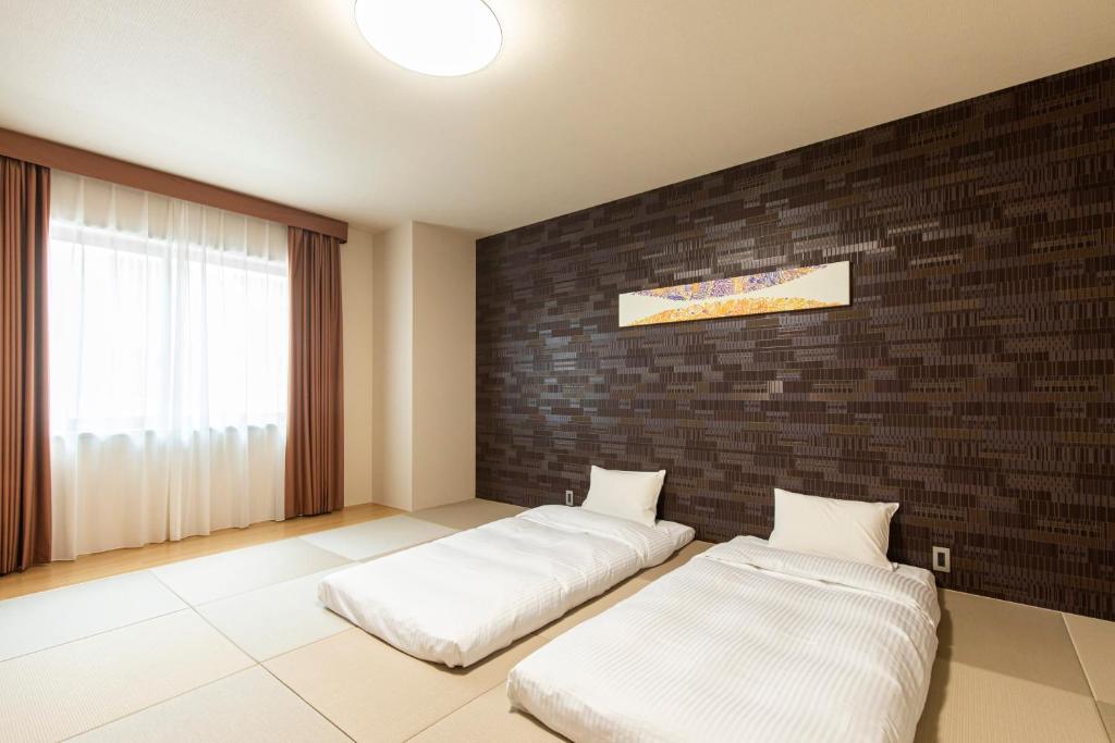 Postel nebo postele na pokoji v ubytování Tabino Hotel lit Matsumoto Milky white Onsen
