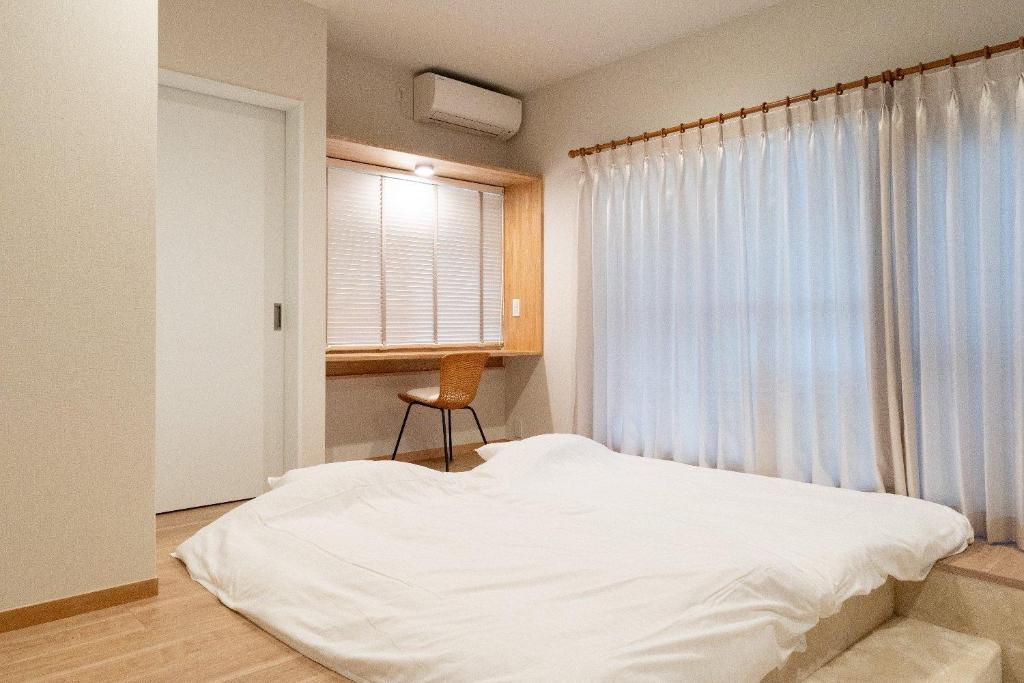 a bedroom with a white bed and a window at n'estate Yamanakako Tsutsuji in Yamanakako