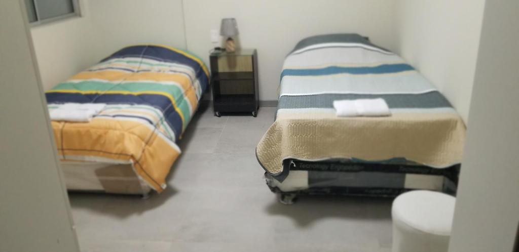 two beds sitting next to each other in a room at Departamento amplio y seguro 