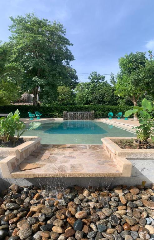 - une piscine avec une fontaine et des rochers dans l'établissement Hostal La Media Luna Palomino, à Palomino