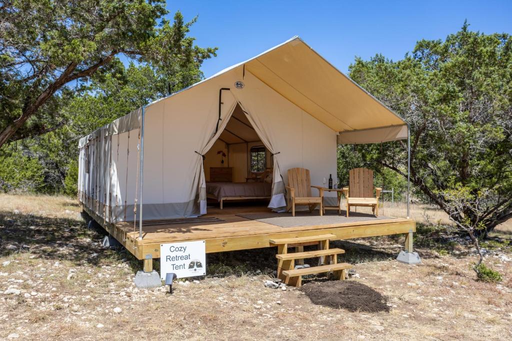 a tent with a table and chairs in a field at Cozy Retreat Glamping Tent - Twin Falls in Boerne