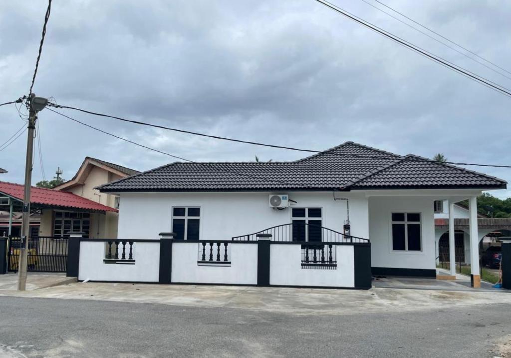 a white house with a black roof at 13 Avenue Homestay in Kota Bharu