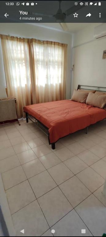 - une chambre avec un grand lit et une couverture rouge dans l'établissement Raudhah family homestay at KLIA 3rooms & 2bath room, à Sepang