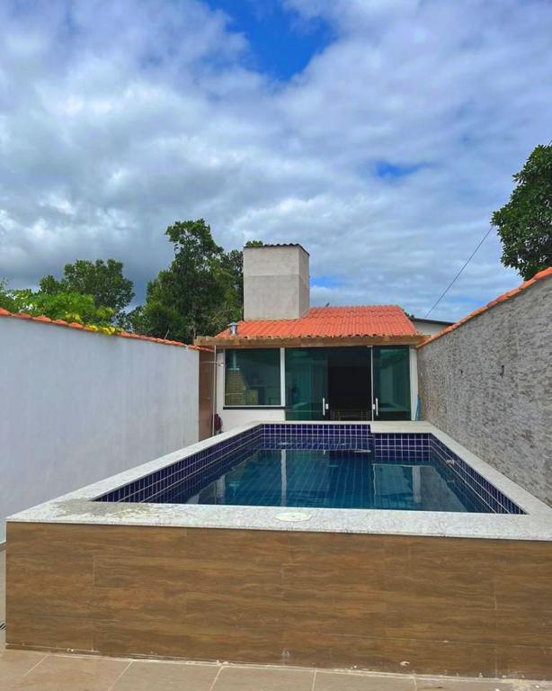 een huis met een zwembad voor een gebouw bij Espaço praia boraceia in Bertioga